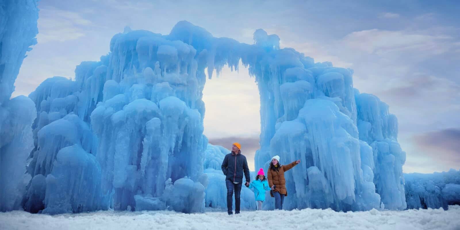 family stands under an arch made of ice in Colorado