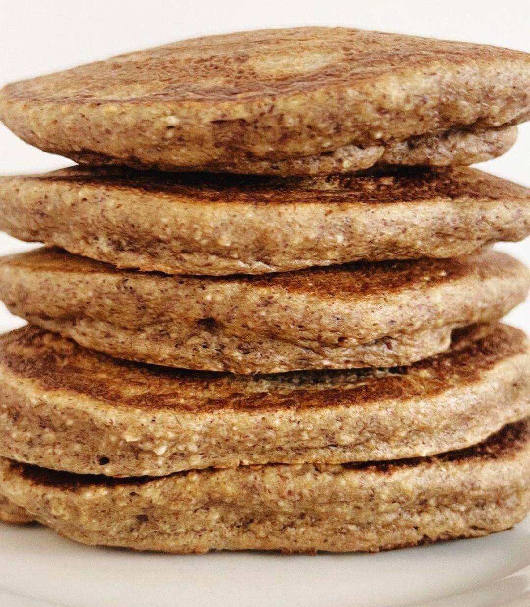 stack of almond, oats and banana fried pancakes on whitee plate