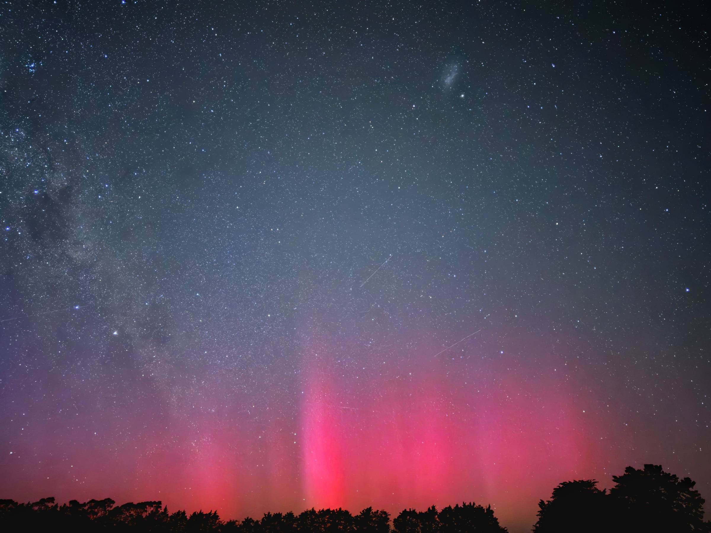 pink glow of auroa with milky way and shooting stars