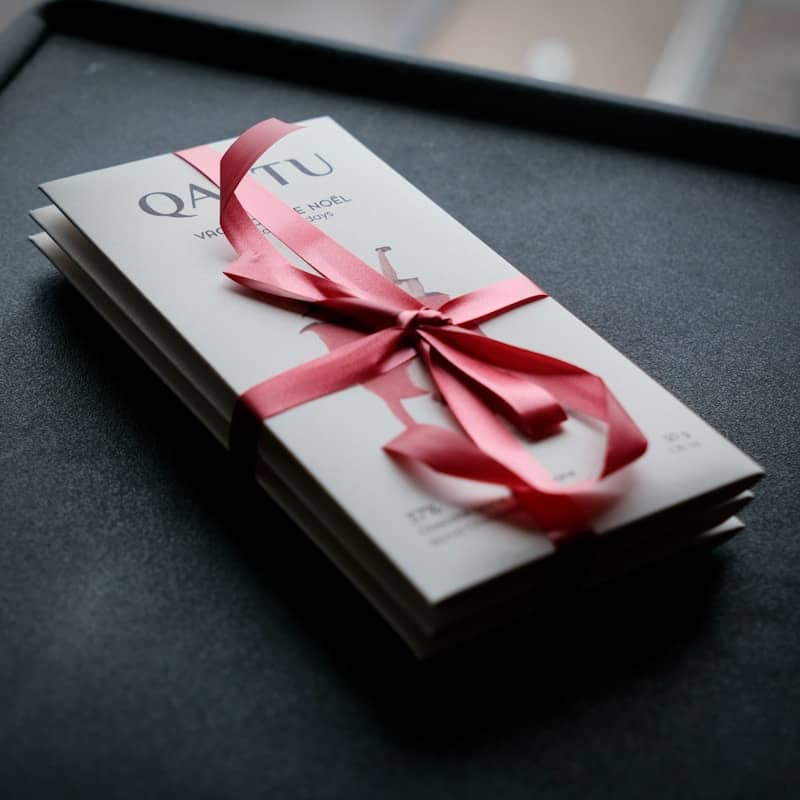A booklet or brochure tied with a pink ribbon.