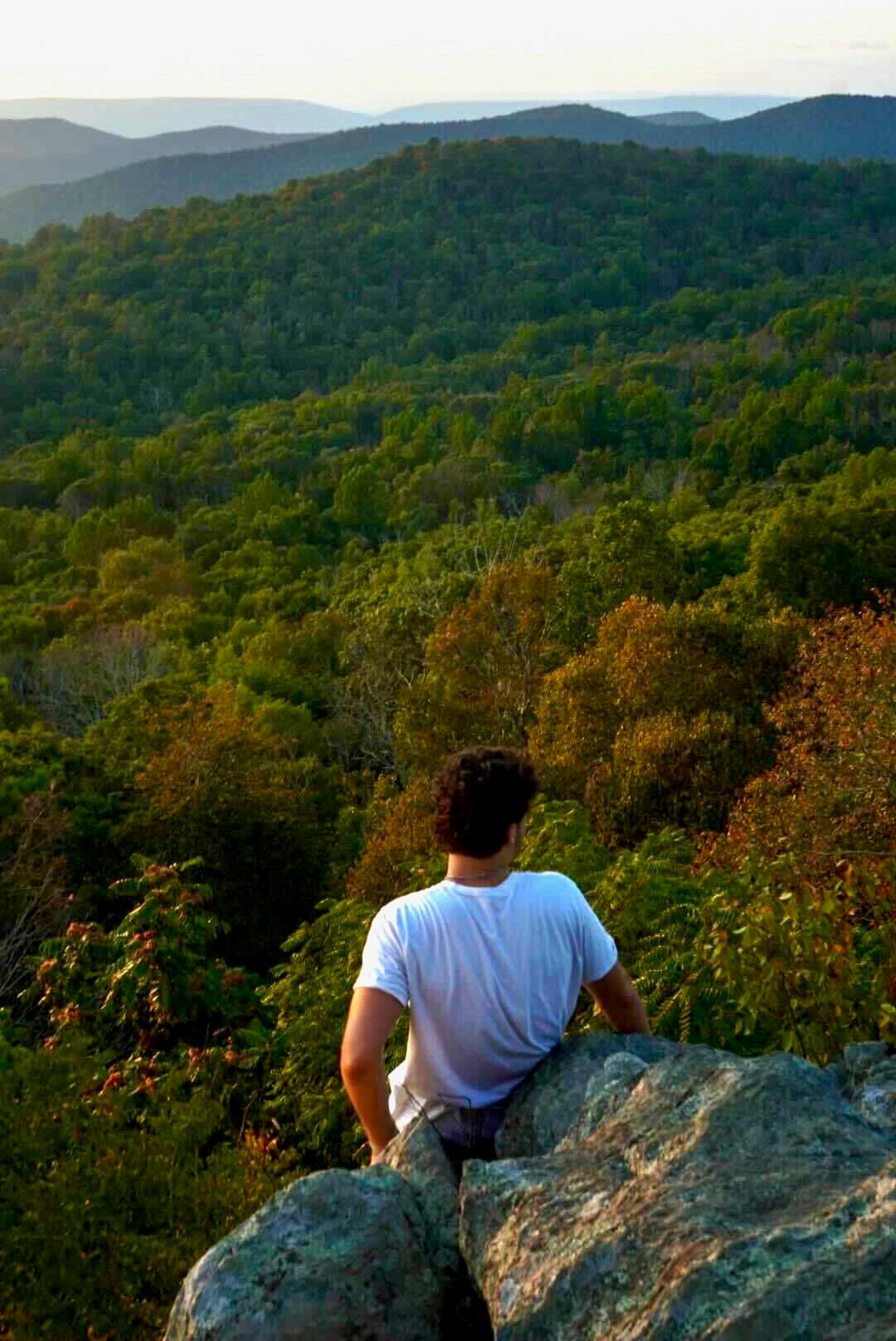 Looking at sunset over fall foliage from a cliff