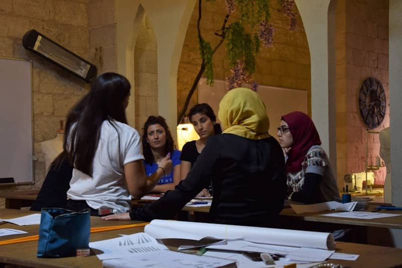 Group of women sitting around a table discussing.