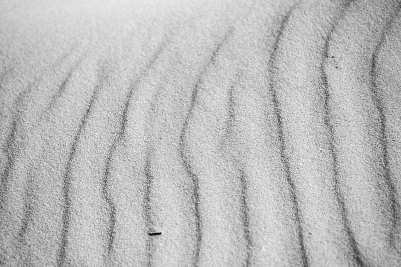Rippled sand patterns in black and white.