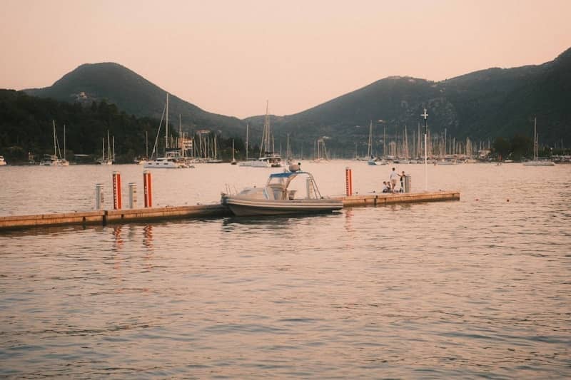 Sunset over a bay with boats docked at a pier.
