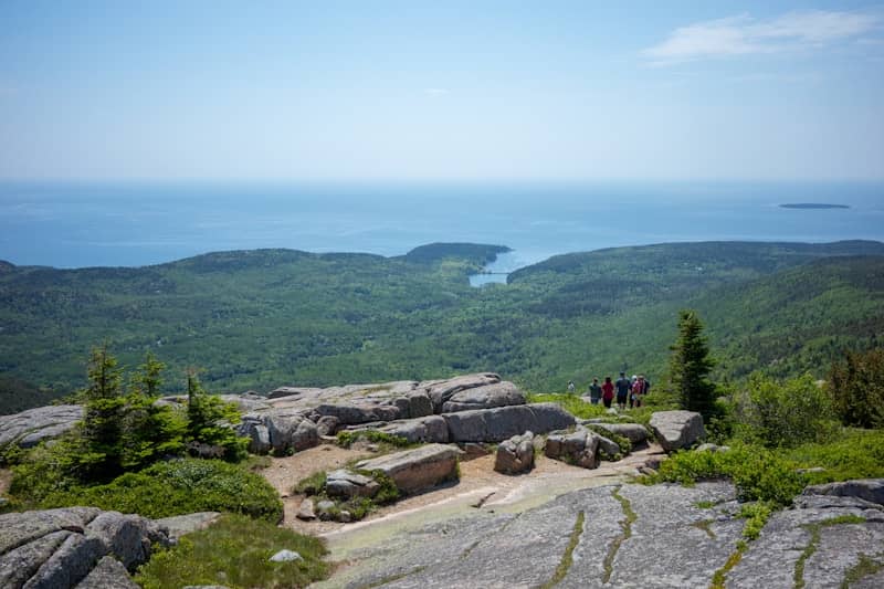 Hikers on a rocky overlook with ocean view