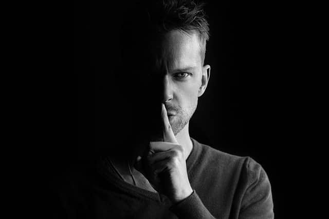 Man raising finger to his lips