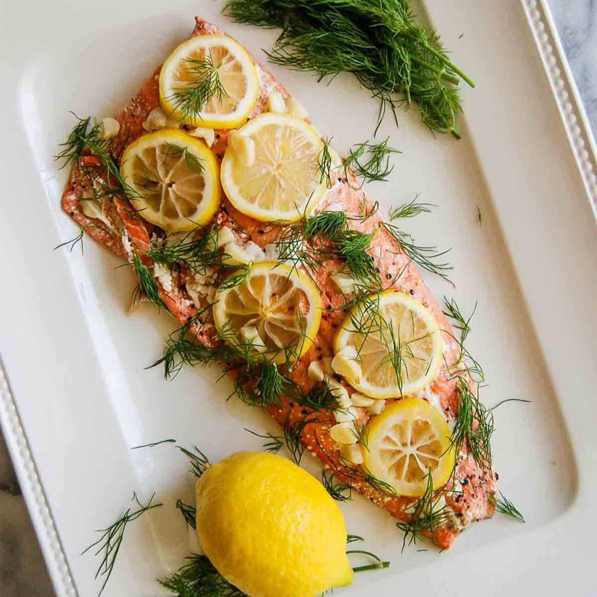 baked salmon on plate with lemon and dill
