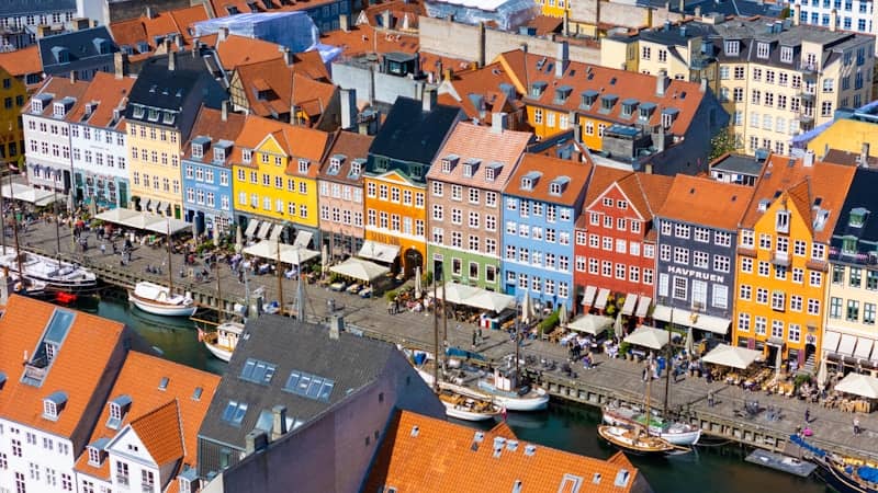 Colorful buildings line a canal in a vibrant cityscape.