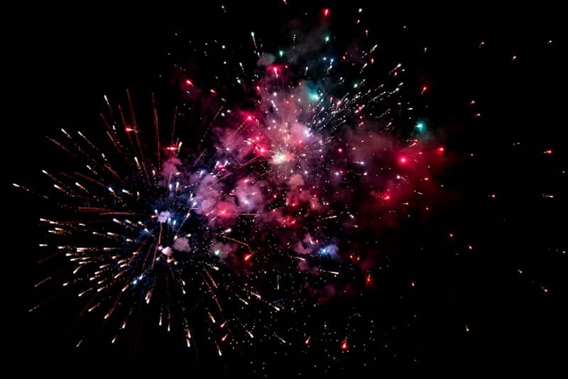 a colorful fireworks is lit up in the night sky