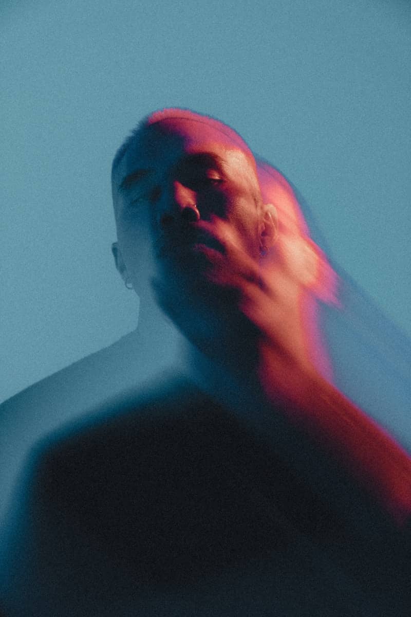 Man with blurred face in red and blue light