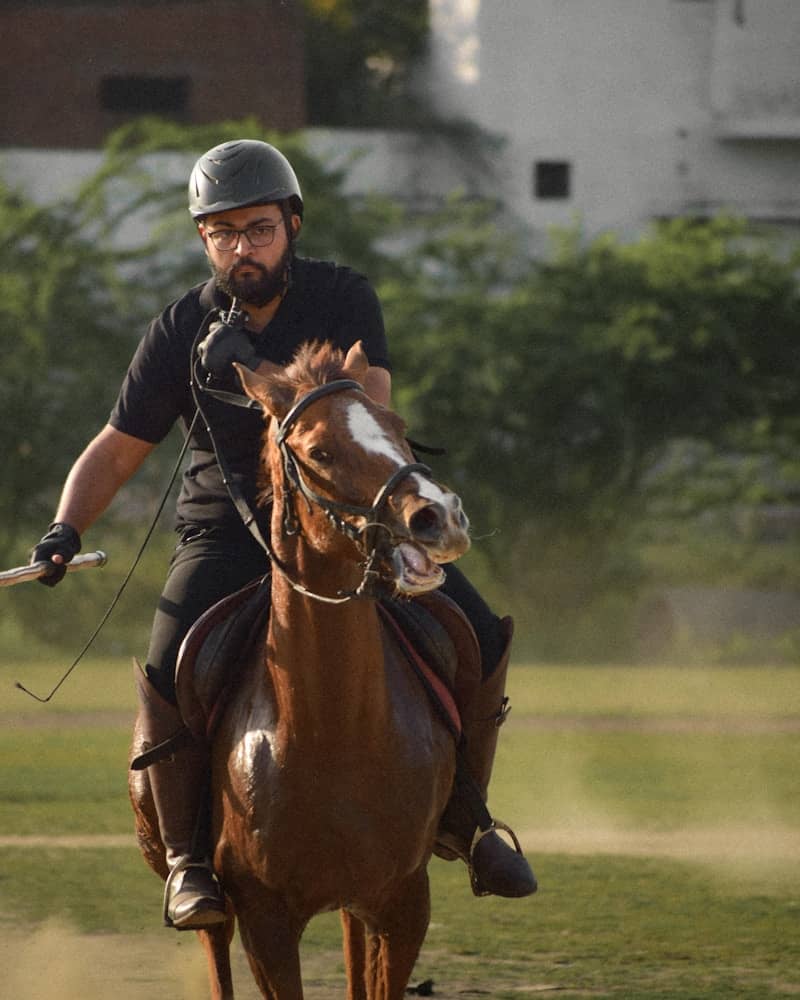 Man riding a horse with a helmet
