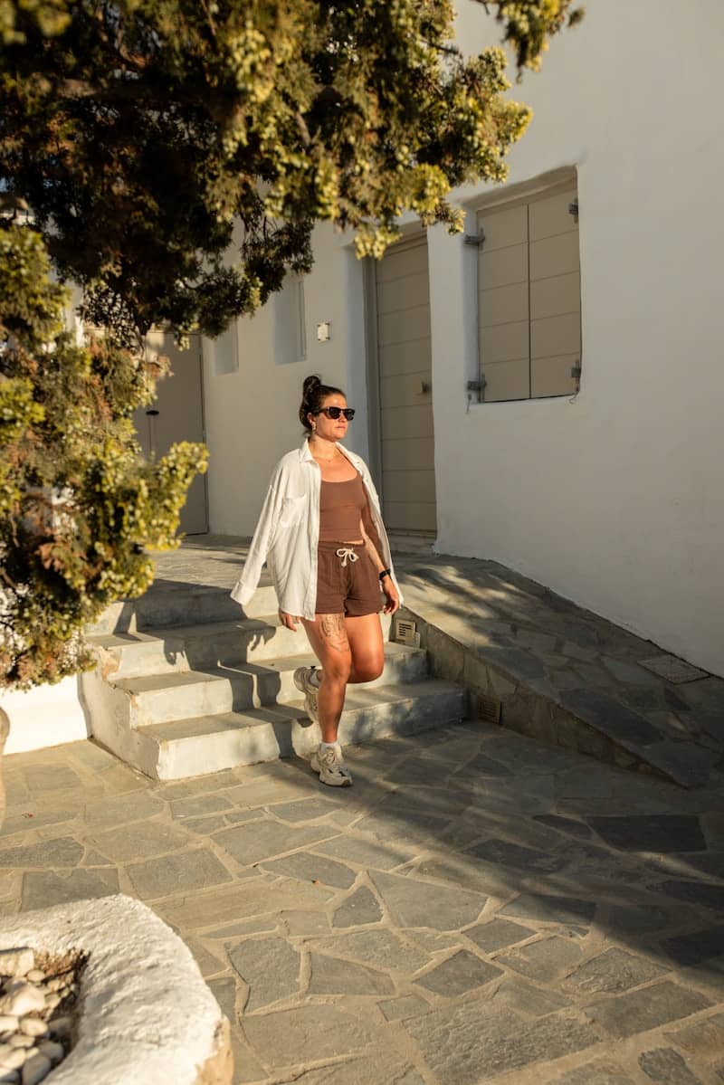 Woman walking down stone path in milos, greece