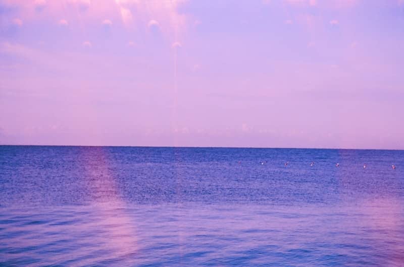 Calm ocean under a pastel pink and purple sky