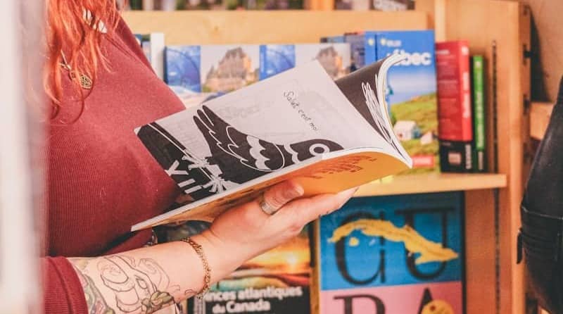 Woman reading a travel guide in a bookstore.