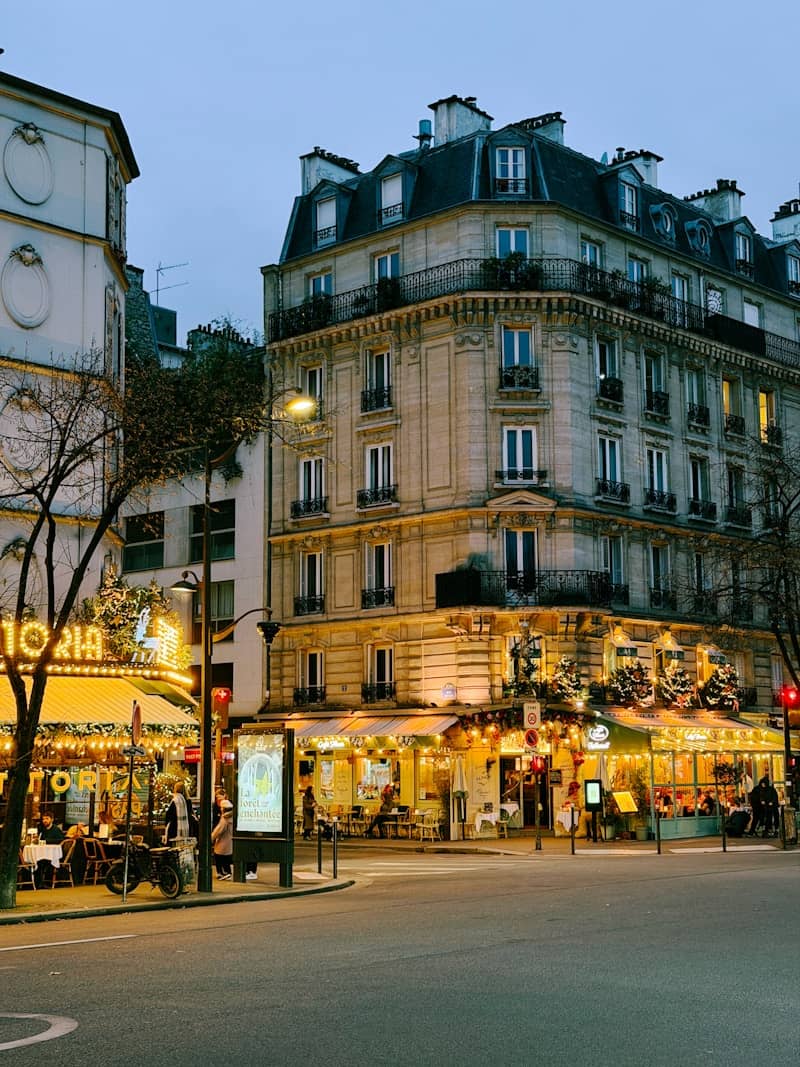 Parisian street corner with illuminated buildings at dusk