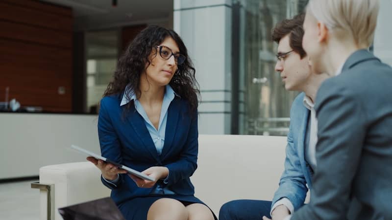 Three professionals in a business meeting discussion