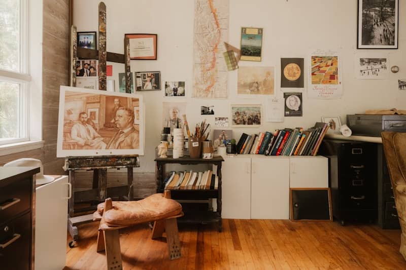 Creative artist's studio with easel, books, painting, and art supplies - valiant scribe