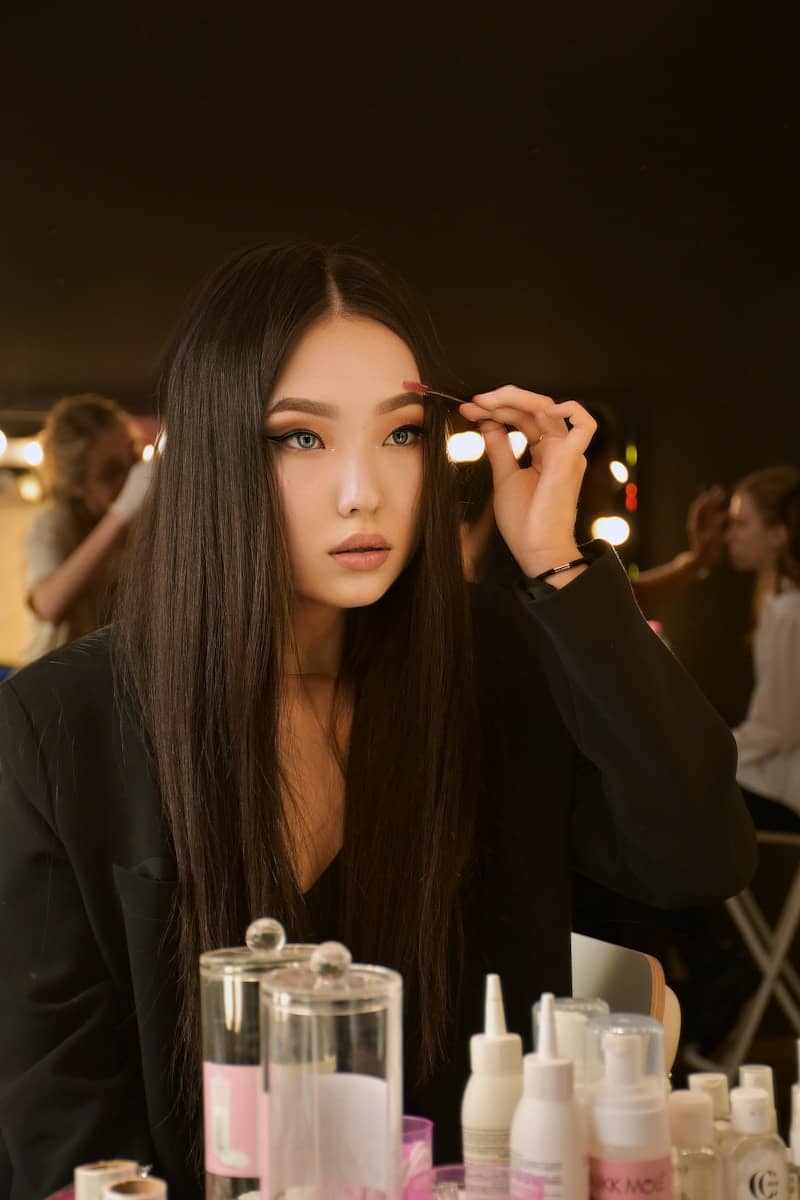 woman in black long sleeve shirt holding her hair