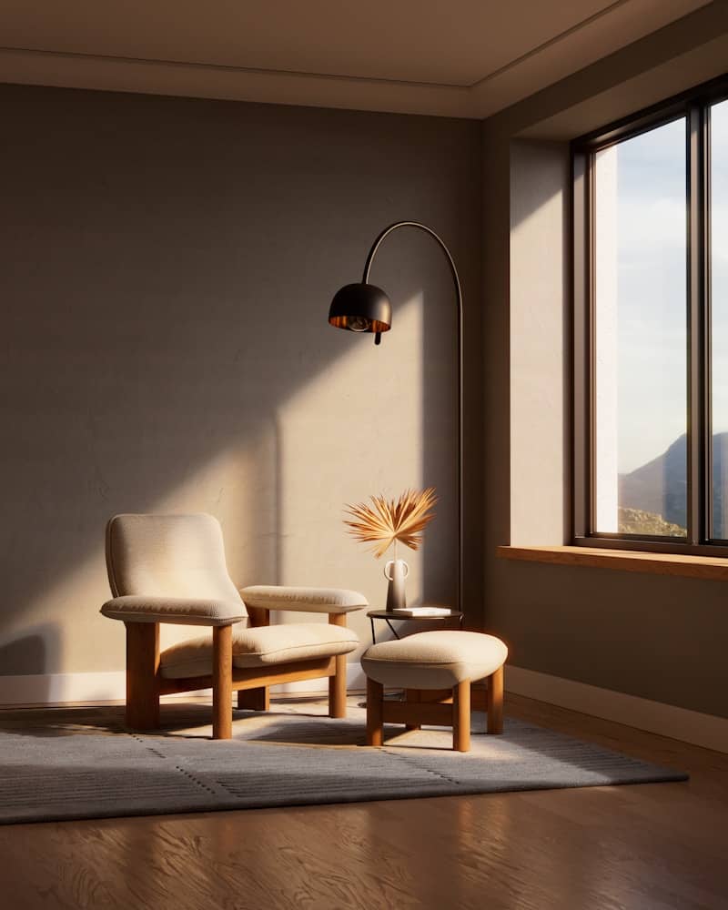 Modern armchair and ottoman with floor lamp by window.