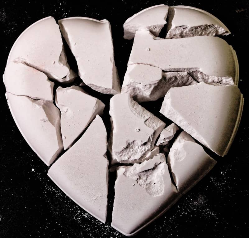 A broken heart shaped cake sitting on top of a table