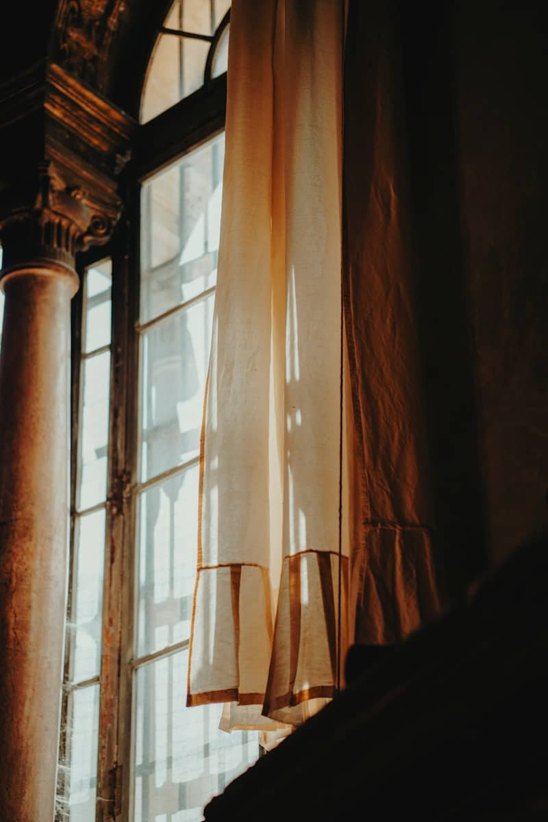 Sunlight streams through curtains near a window.