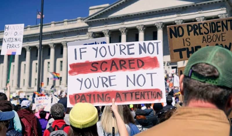 Protestors hold signs during a political demonstration.
