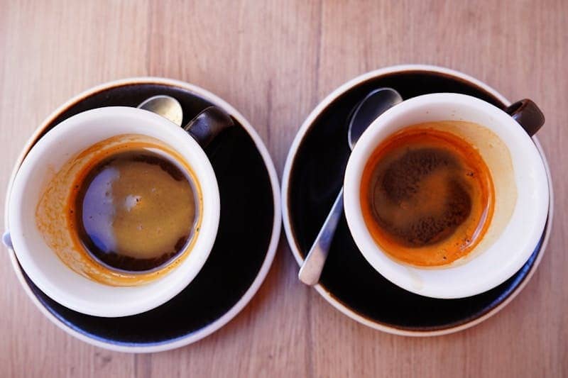 A couple of cups of coffee sitting on top of a wooden table