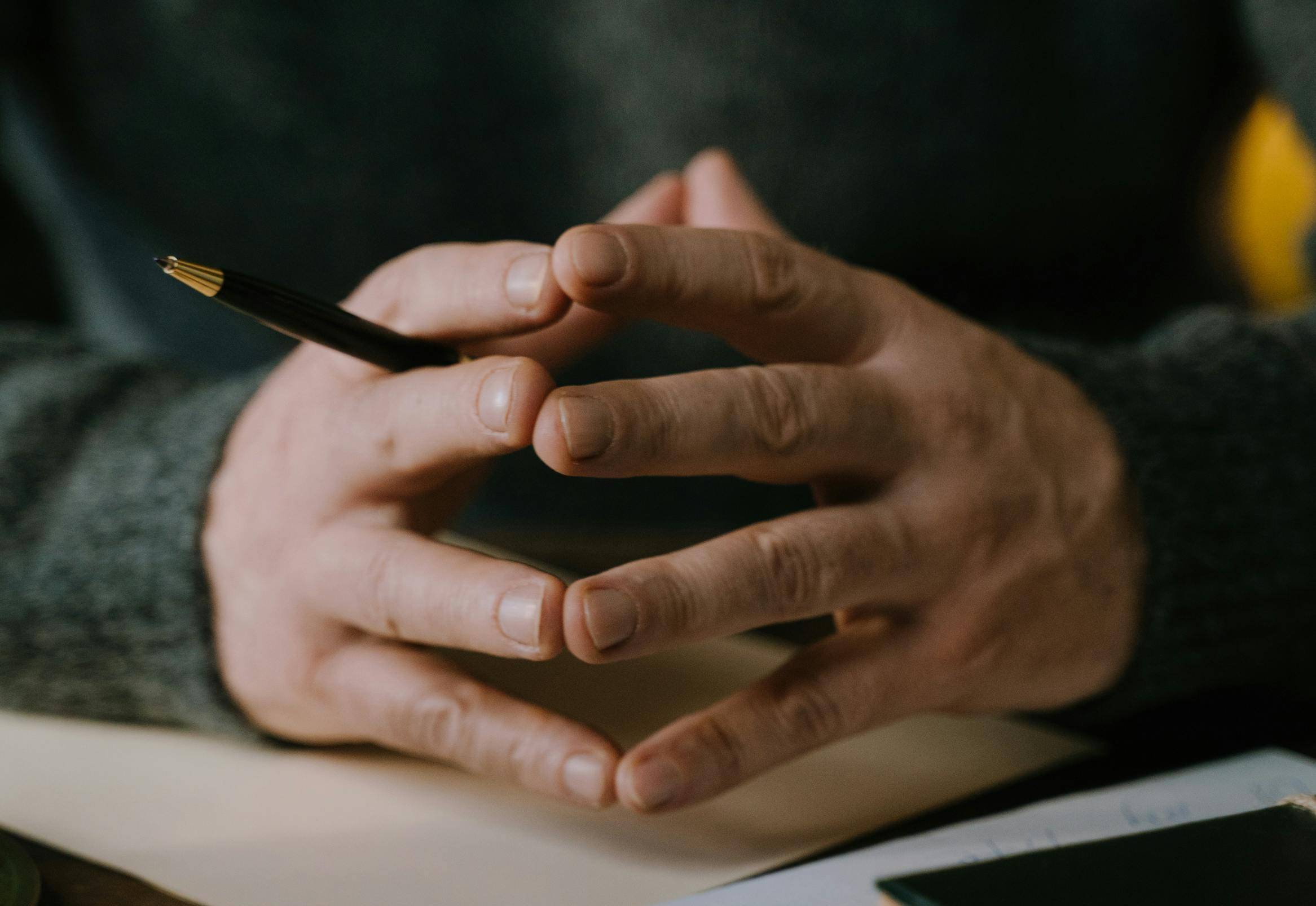 Hands with pen over book 