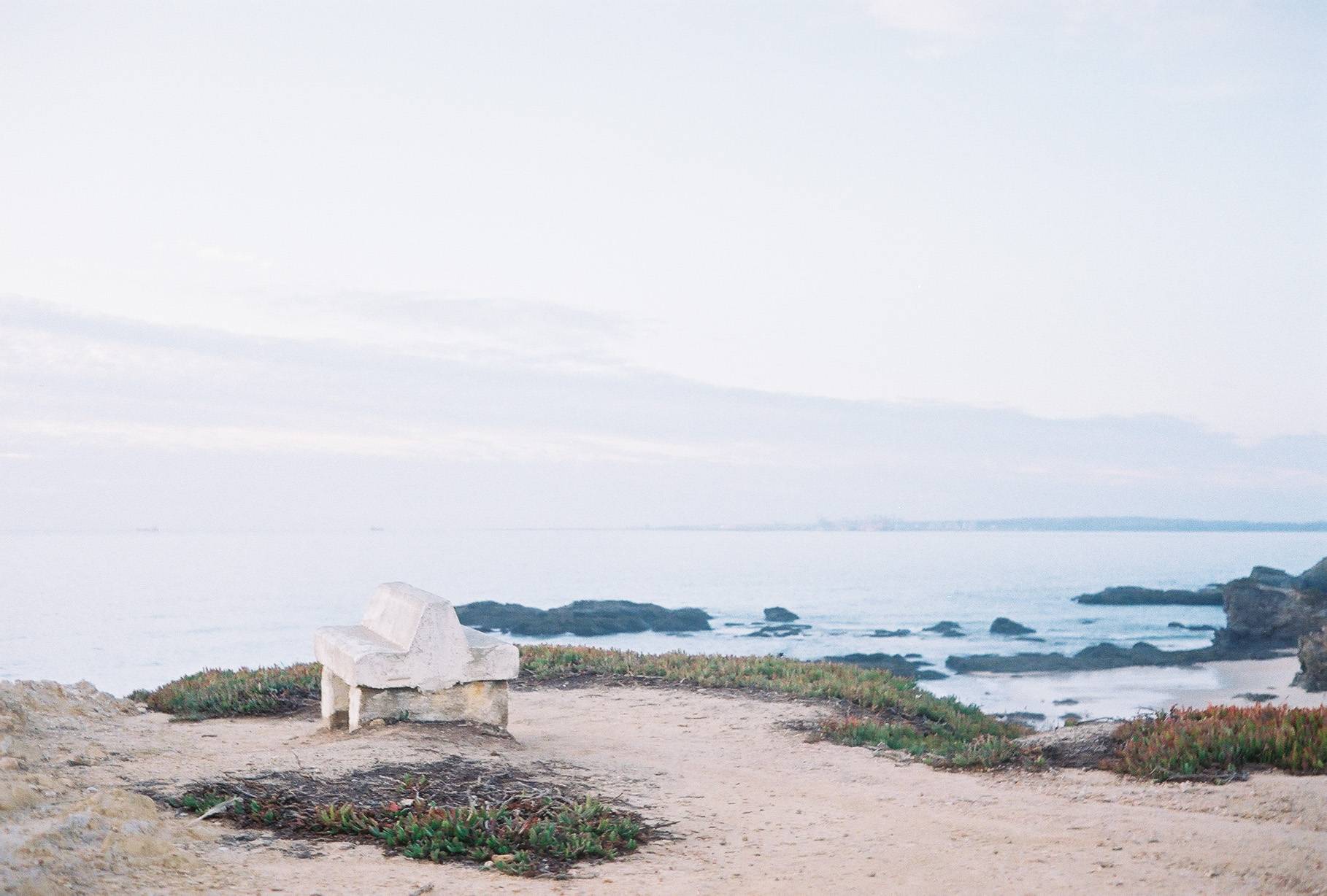 bench on a cliff with ocean on the background