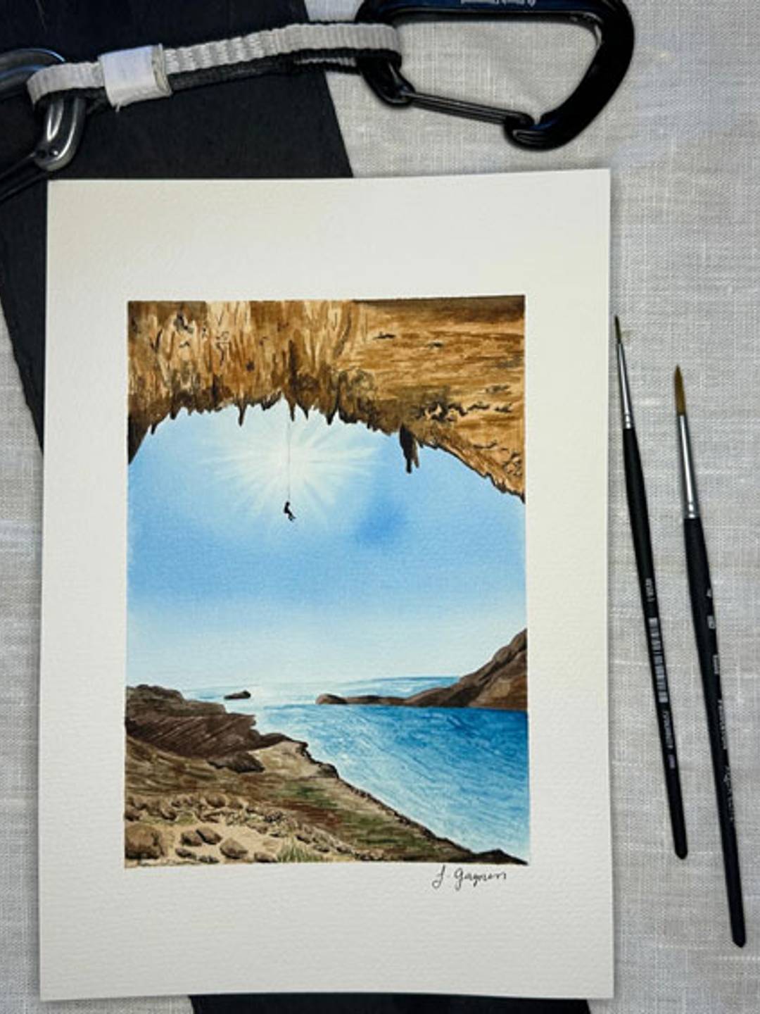 watercolor painting of a rock climber hanging overlooking the ocean