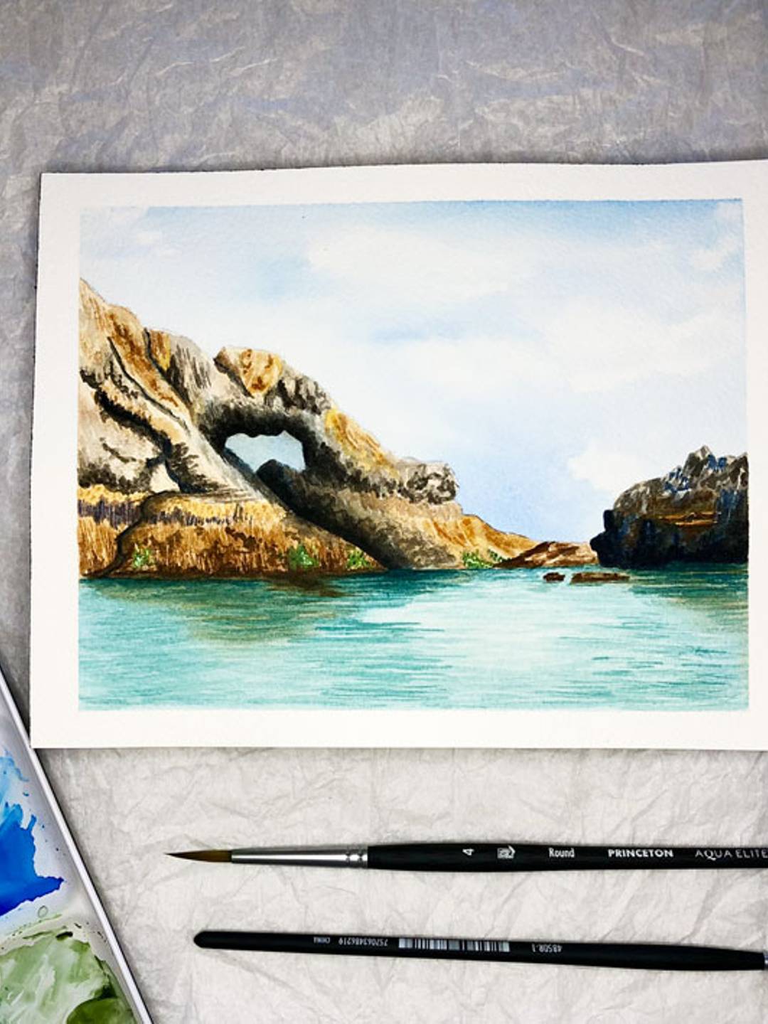 watercolor painting of a rock arch in the oceans
