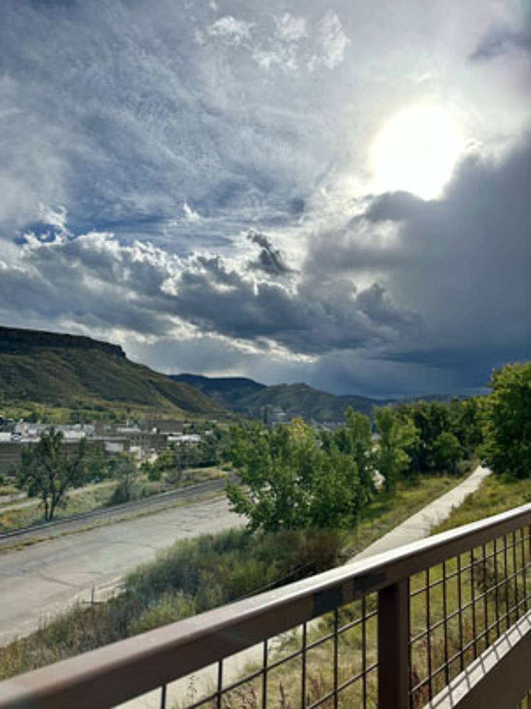 clear creek bike path with stormy skies towards the mountains