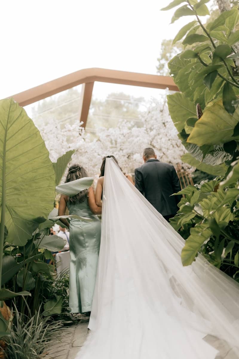 Bride walking down aisle with veil and attendants
