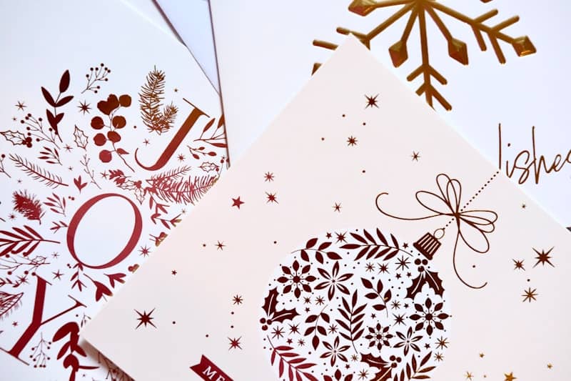 Christmas cards with festive gold and red designs.