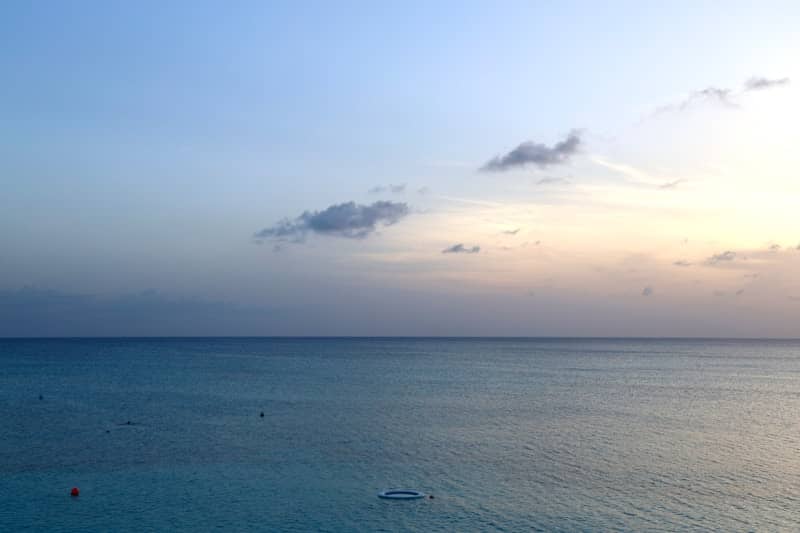 Calm ocean under a beautiful twilight sky with faint clouds.