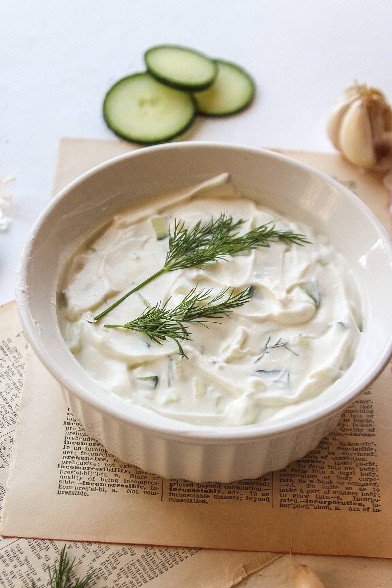 a bowl of tzatziki with dill on top.