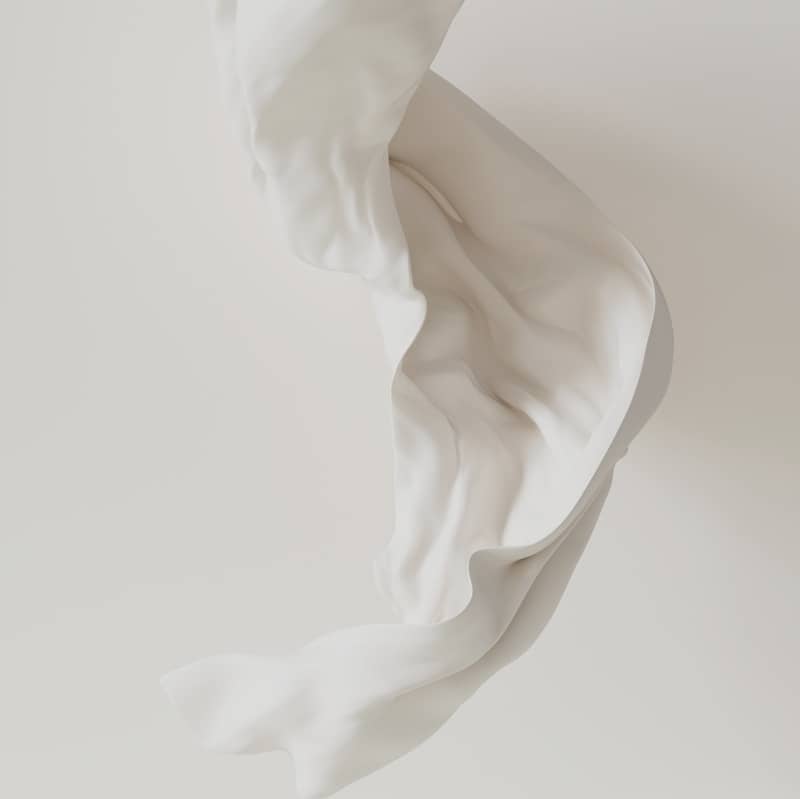 A flowing white cloth against a white backdrop.