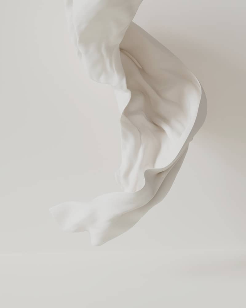 A flowing white cloth against a white backdrop.