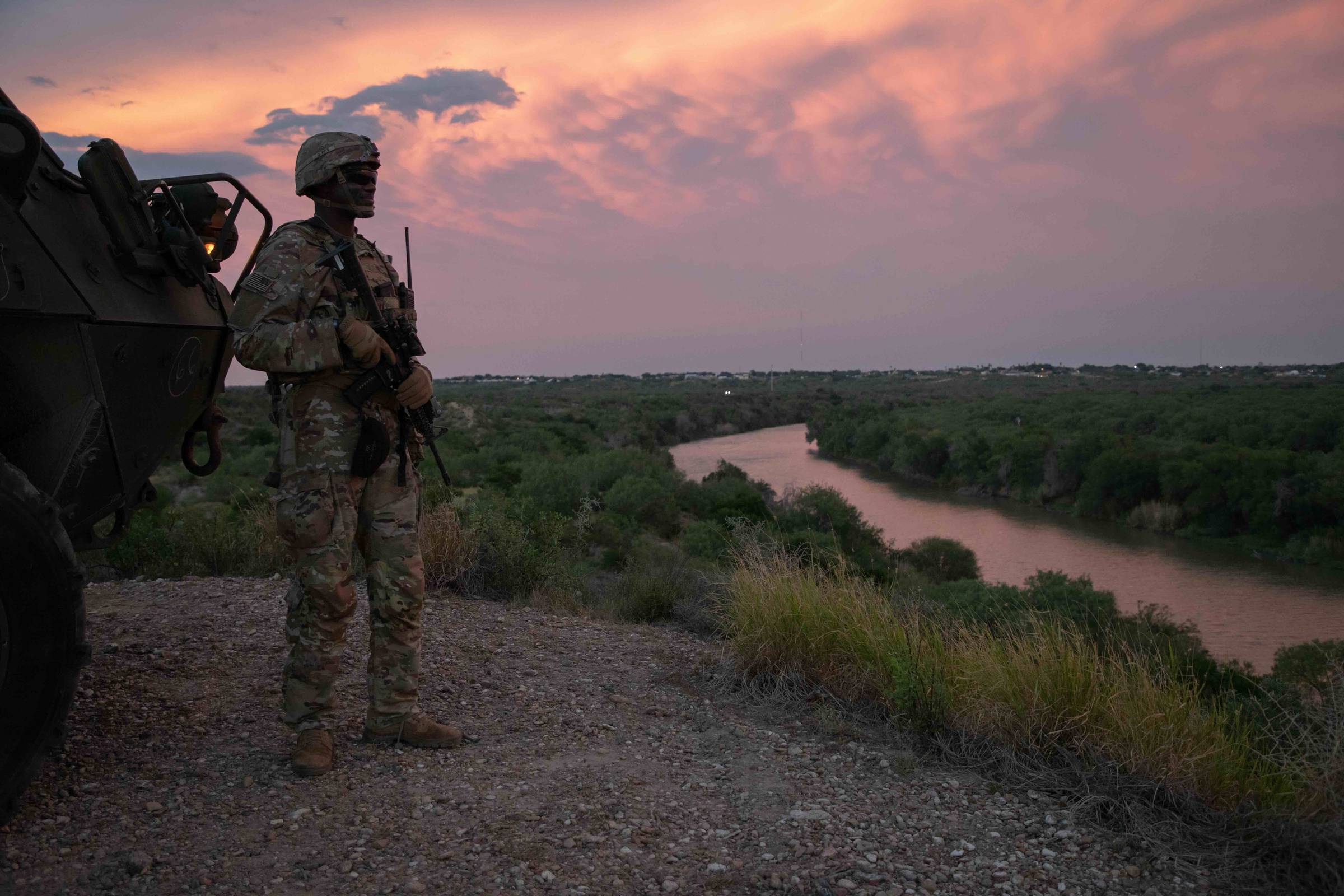 A U.S. Army soldier assigned to Charlie Company, 1st Battalion, 41st Infantry Regiment, 2nd Stryker Brigade Combat Team, 4th Infantry Division, stands beside a Stryker to observe the Rio Grande River near Roma, Texas, June 12, 2025. (U.S. Army photo by Pf