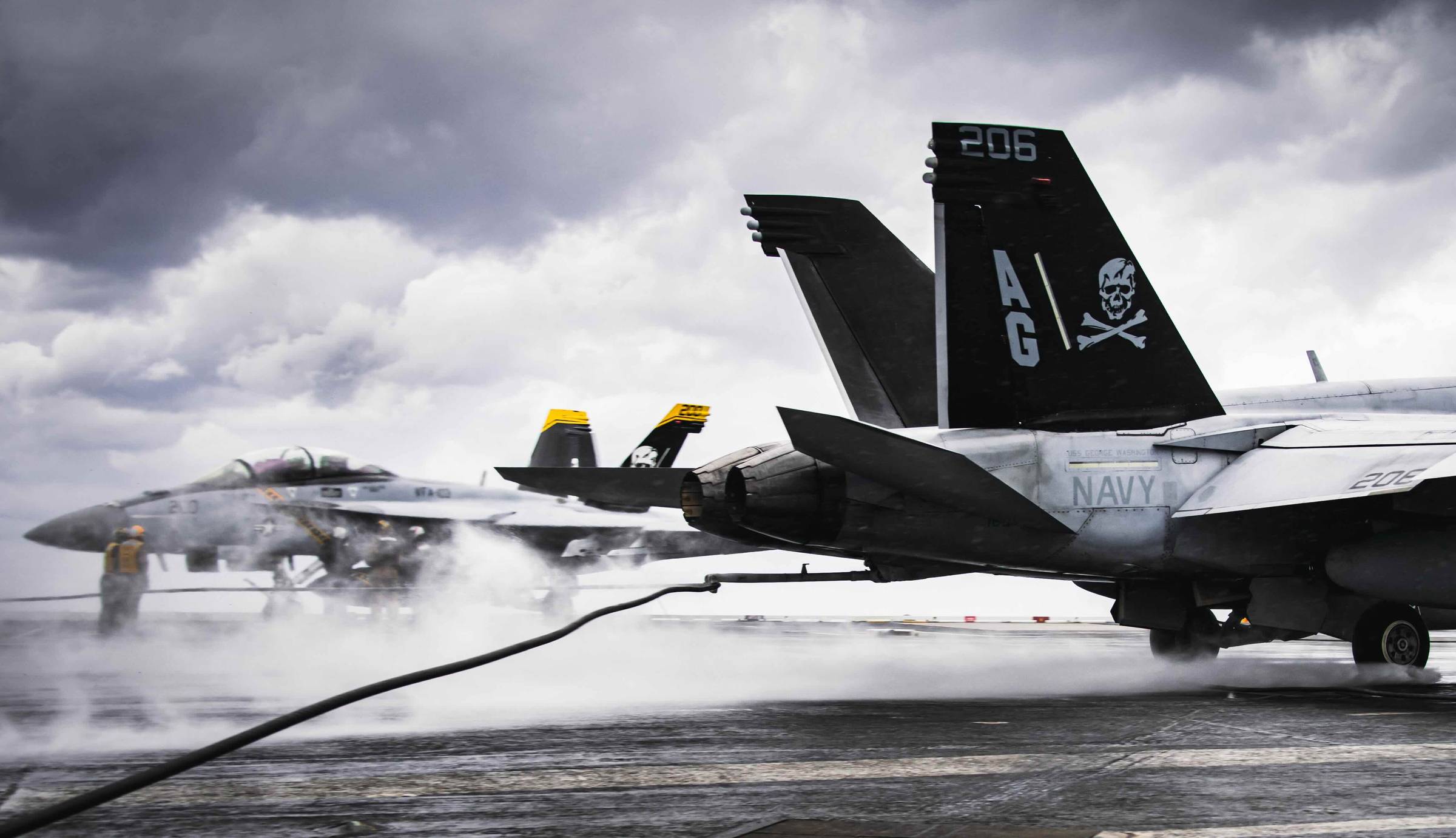An F/A-18E/F Super Hornet from Strike Fighter Squadron (VFA) 103 lands during a rain shower on Nimitz-class aircraft carrier USS George Washington (CVN 73) Dec. 6, 2023 (U.S. Navy Photo by Mass Communication Specialist 3rd Class August Clawson)