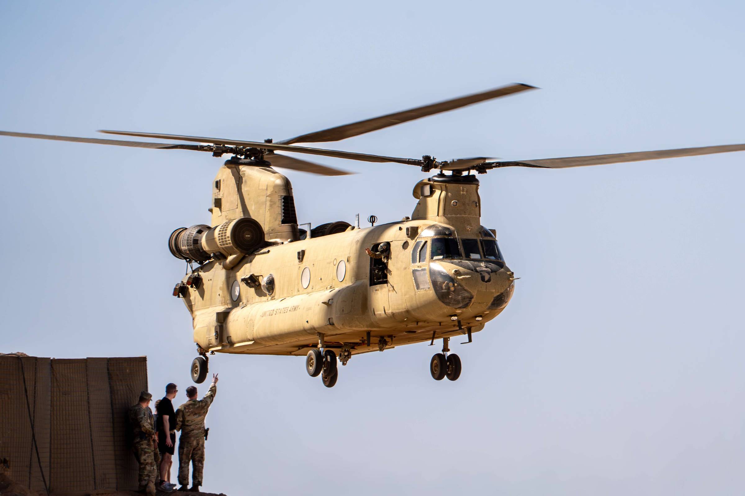 A U.S. Army CH-47 Chinook hovers past Soldiers of Golf Company, Task Force CARDINAL on May 10, 2025, at Al-Asad Airbase, Iraq (U.S. Army photo by Staff Sgt. Brad C. Stepien)