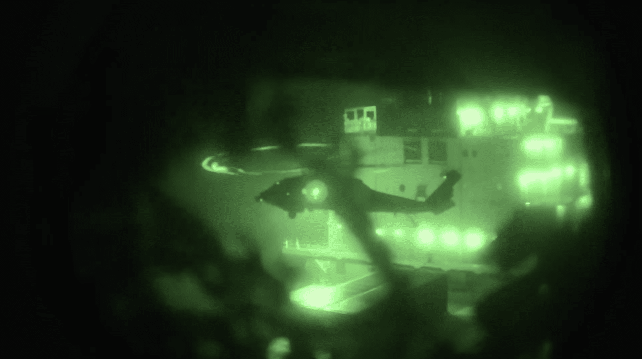 A night-vision screenshot shows U.S. Marines departing USS Tripoli (LHA 7) by helicopter over the Arabian Sea to board and seize the Iranian-flagged vessel M/V Touska, April 19, 2026. (U.S. Central Command)
