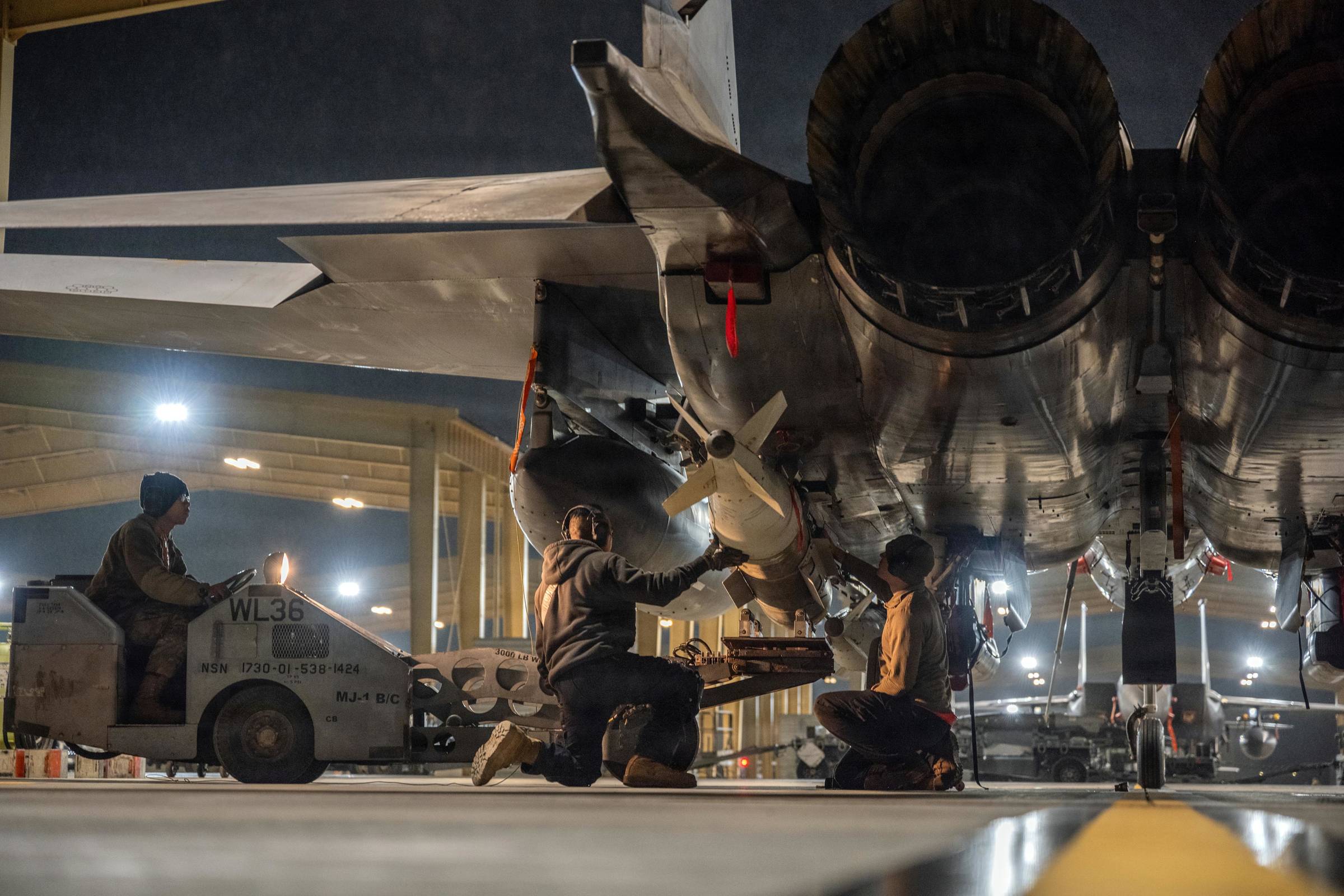 Airmen load bombs onto F-15E Strike Eagles at a base in the U.S. Central Command area of responsibility in support of Operation Hawkeye Strike, Jan. 10, 2026. (Air Force Photo)