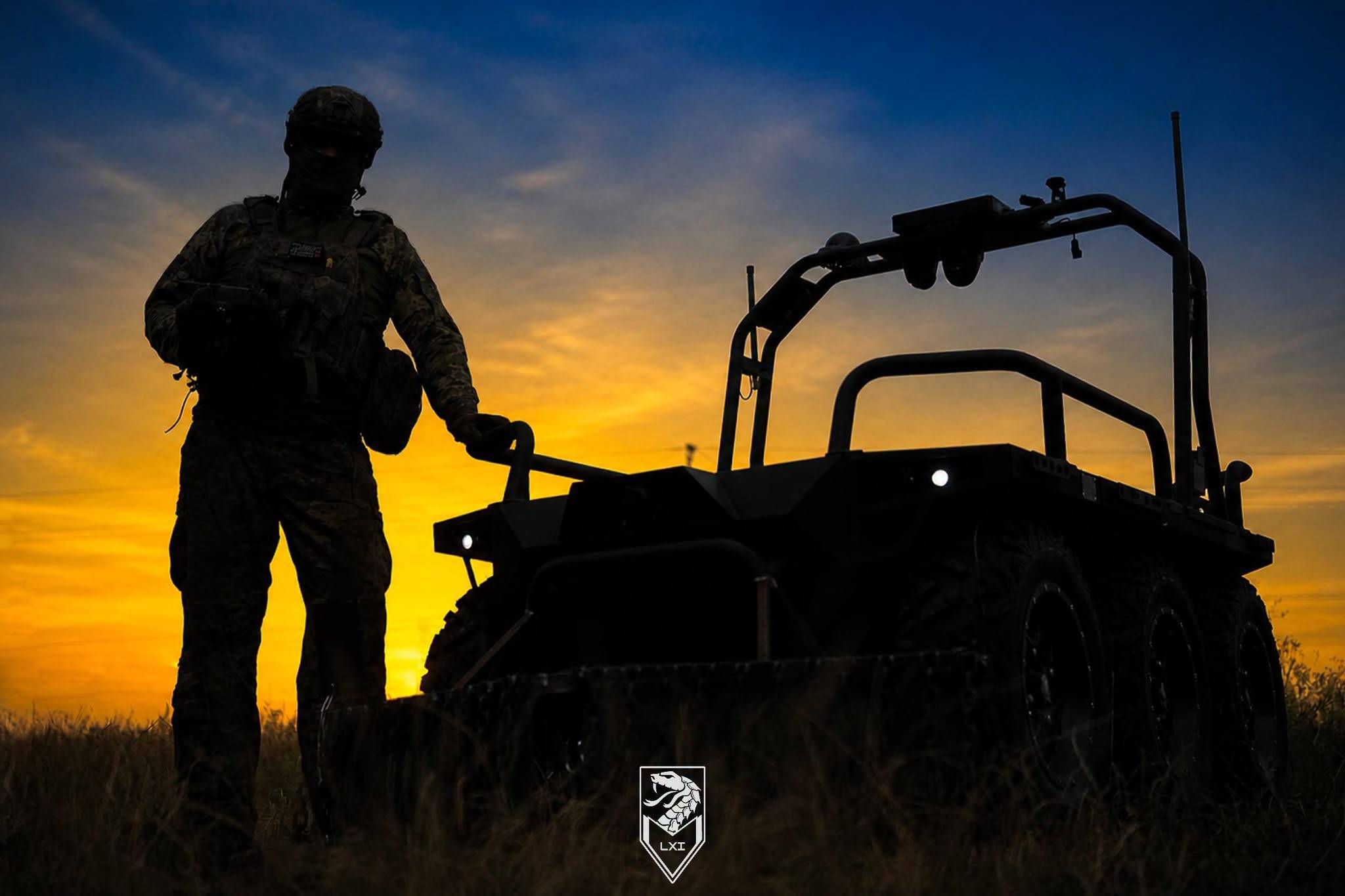 A Ukrainian soldier with the 61st Mechanized Brigade stands beside an unmanned ground vehicle at sunset. (Credit: 61st Mechanized Brigade)