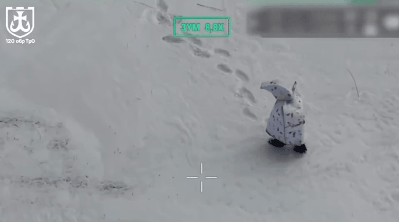 A Russian soldier wearing a distinctive winter camouflage suit that online observers have likened to a penguin moves across snow-covered terrain. Ukraine’s 120th Territorial Defense Brigade said its troops engaged at least two Russian soldiers using FPV d