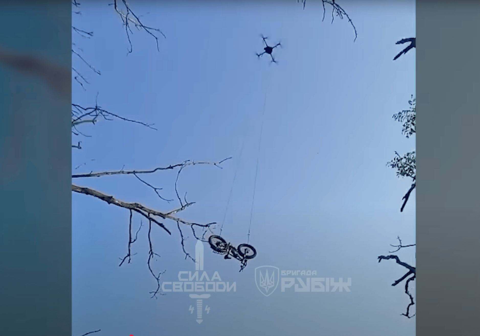 A screenshot from the YouTube video released by Ukraine’s National Guard brigade Rubizh, showing an e-bike being lowered by an FPV drone for a Ukrainian soldier stuck behind Russian lines. (Photo: Screenshot via YouTube/Ukraine’s National Guard brigade Ru