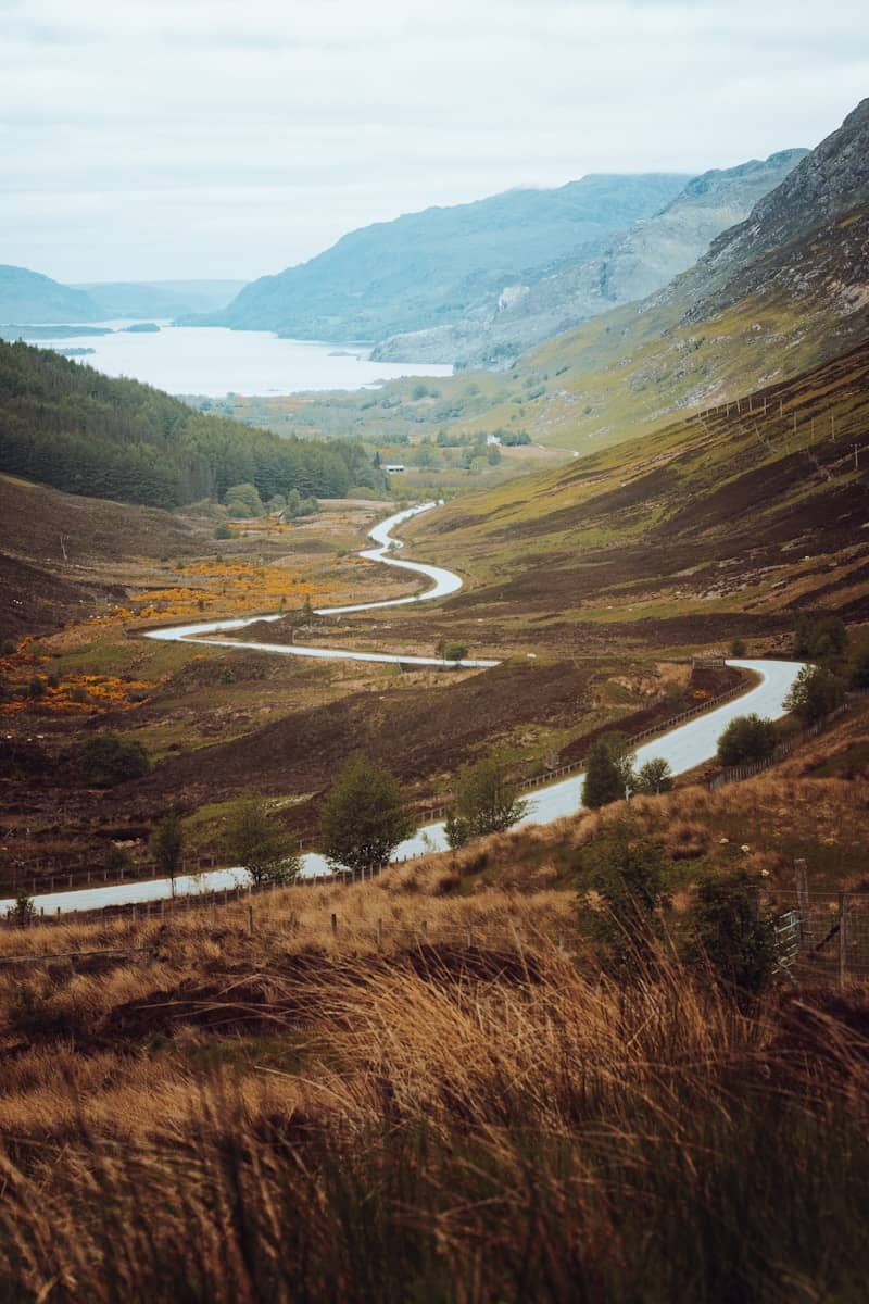 a scenic view of a winding road in the mountains