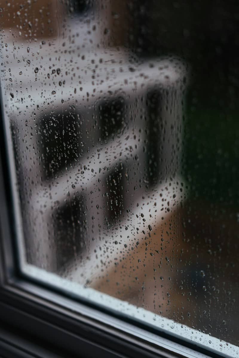 Raindrops on a window pane with a blurred building in the background