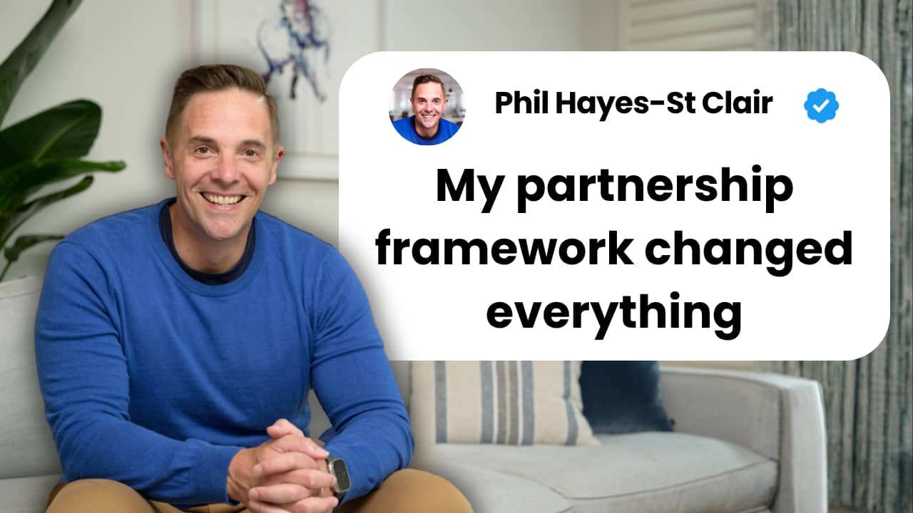 Phil Hayes-St Clare smiling at camera in blue sweater, sitting in modern office with white text bubble displaying "My partnership framework changed everything" next to his name and verification checkmark on white rounded rectangle background