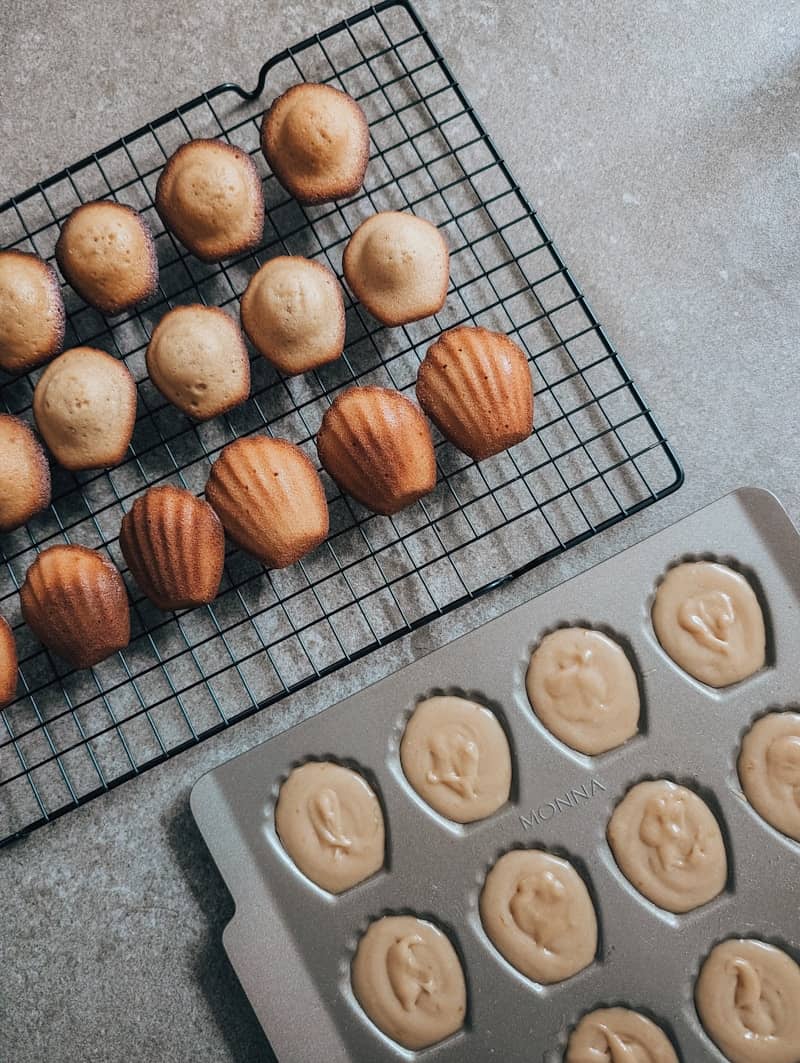 Madeleines on a rack, and batter in a pan.